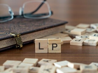 the acronym lp for limited partner word or concept represented by wooden letter tiles on a wooden...