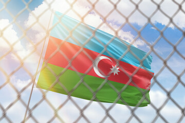 A steel mesh against the background of a blue sky and a flagpole with the flag of azerbaijan