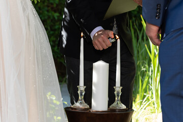 Lighting the individual candles for the bride and groom that will signify the union of the two in...