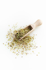 Wooden scoop whith dried oregano. Isolated on white background. Top view.