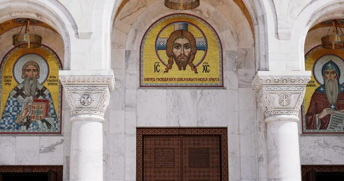 entrance to the Orthodox Church with mosaic frescoes and marble and wooden doors