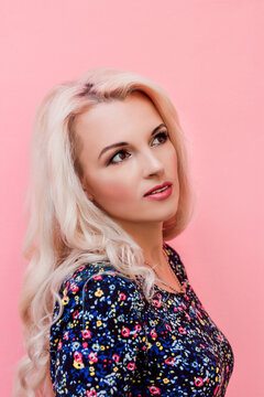 Young beautiful blonde in retro style on a pink background