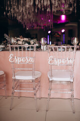 chairs of the newlyweds at the festive table with the inscription