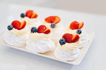 strawberries, blueberries and cream decorates to Anna Pavlova cakes.