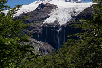 Alpine landscape. View of glacier Castaño Overo white ice field in Tronador hill. The green forest...