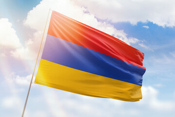 Sunny blue sky and a flagpole with the flag of armenia