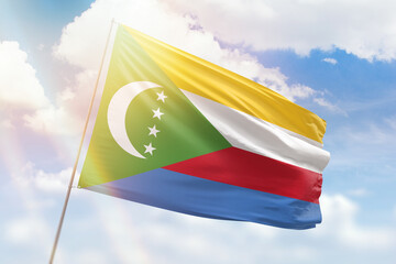 Sunny blue sky and a flagpole with the flag of comoros