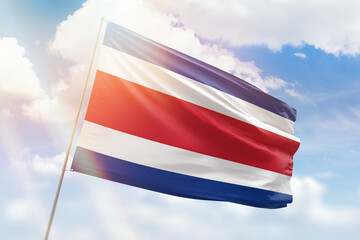 Sunny blue sky and a flagpole with the flag of costa rica