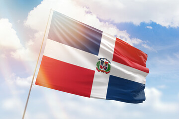 Sunny blue sky and a flagpole with the flag of dominican republic