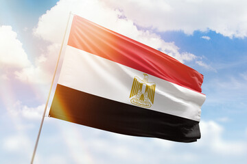 Sunny blue sky and a flagpole with the flag of egypt