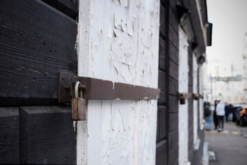 old white cracked shutters of a wooden building in town