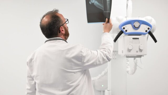 Doctor examine a film x-ray of a patient at radiology room. High quality 4k footage