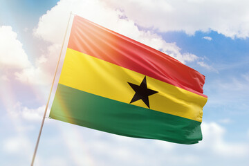 Sunny blue sky and a flagpole with the flag of ghana