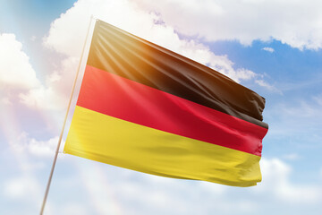 Sunny blue sky and a flagpole with the flag of germany