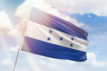 Sunny blue sky and a flagpole with the flag of honduras