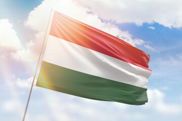 Sunny blue sky and a flagpole with the flag of hungary