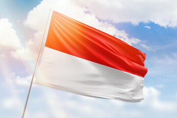 Sunny blue sky and a flagpole with the flag of indonesia