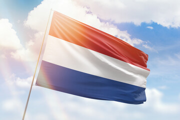 Sunny blue sky and a flagpole with the flag of netherlands