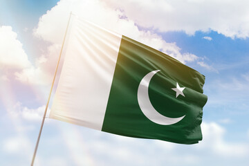 Sunny blue sky and a flagpole with the flag of pakistan