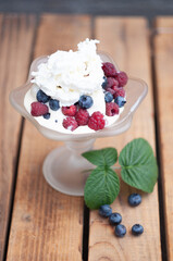 Vanilla ice cream with fresh berries and whipped cream, summer dessert 
