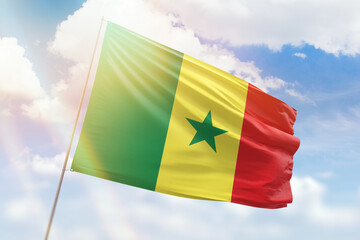 Sunny blue sky and a flagpole with the flag of senegal