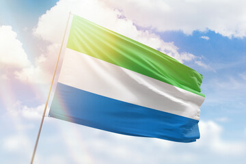 Sunny blue sky and a flagpole with the flag of sierra leone