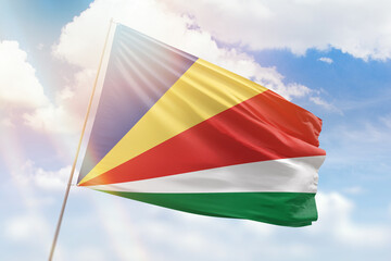 Sunny blue sky and a flagpole with the flag of seychelles