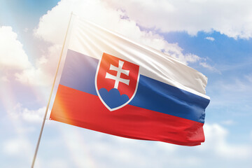 Sunny blue sky and a flagpole with the flag of slovakia