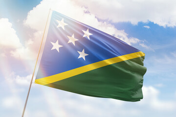 Sunny blue sky and a flagpole with the flag of solomon islands