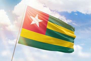 Sunny blue sky and a flagpole with the flag of togo