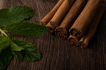 Mint and cinnamon on a dark wood background with copy space