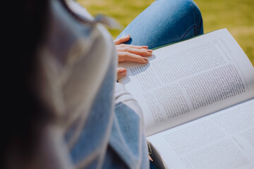 Plano cerrado de una mujer leyendo un libro en un parque.