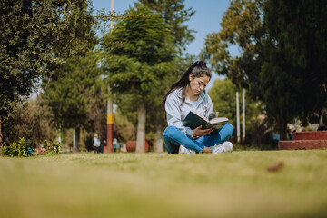 Fototapeta premium Mujer sentada en un parque leyendo. Concepto de pasatiempos y estudios.