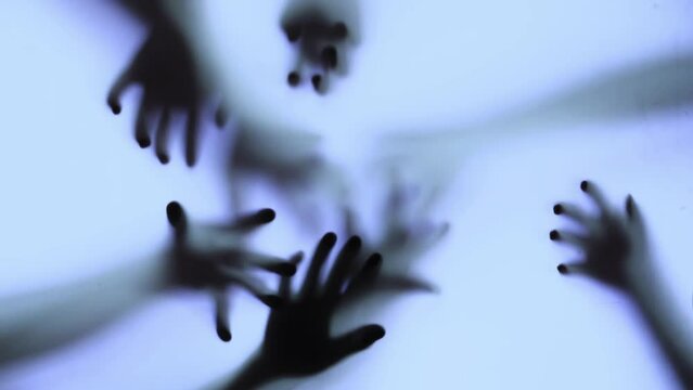 Silhouette of a zombie hand on white background in slow motion
