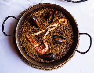Top view of Valencian paella marinera with mussels and shrimps served in traditional metal pan
