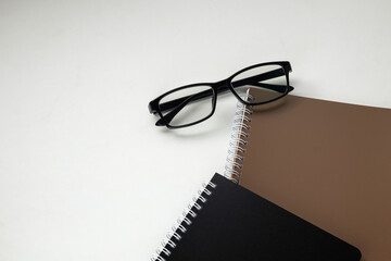 Stylish eyeglasses on white office desk. white work desk