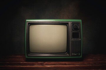 Old green retro TV It's still life on wood table, dark background