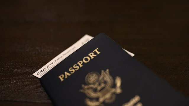 Covid-19 CDC vaccination paper hanging out of the top of a U.S. passport