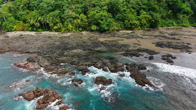 Choco, Colombia. Aerial Drone View Of Vibrant Lush Green Jungle Coast With Deep Blue Waves Crashing Into Rocky Shore.