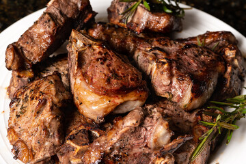 Cooked lamb loin chops with rosemary in a plate.