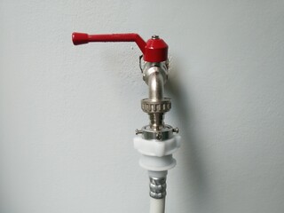Faucet or water tap on the white wall, water supply connection of washing machine