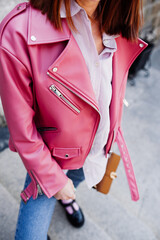 stylish image of urban fashion. bright pink leather jacket and jeans on woman without face. spring female look. cozy style clothes. selective focus