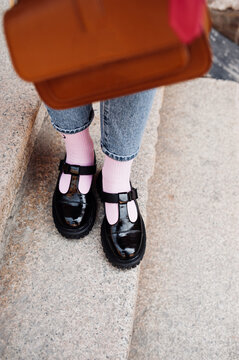 stylish image of urban fashion. stylish black patent leather boots and bright pink socks. selective focus