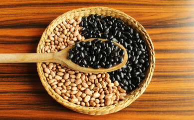 Black turtle beans spoon on the top of brazilian beans in a basket.