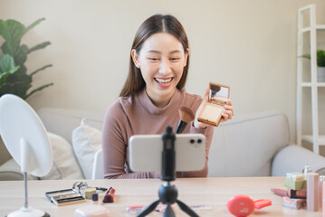 asian female beauty social media influencer livestream marketing cosmetics a make up tutorial via smartphone. - obrazy, fototapety, plakaty