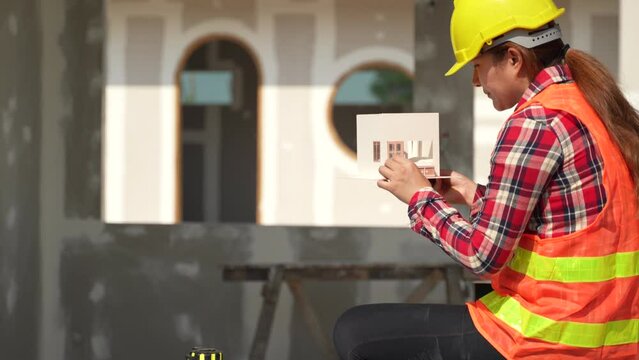 Engineering and architect woman working with house model at the construction property site.