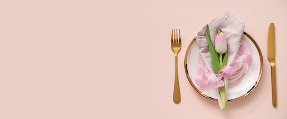 Simple spring table setting on pink background with space for text
