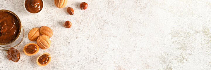 Tasty walnut shaped cookies with boiled condensed milk on grunge background with space for text
