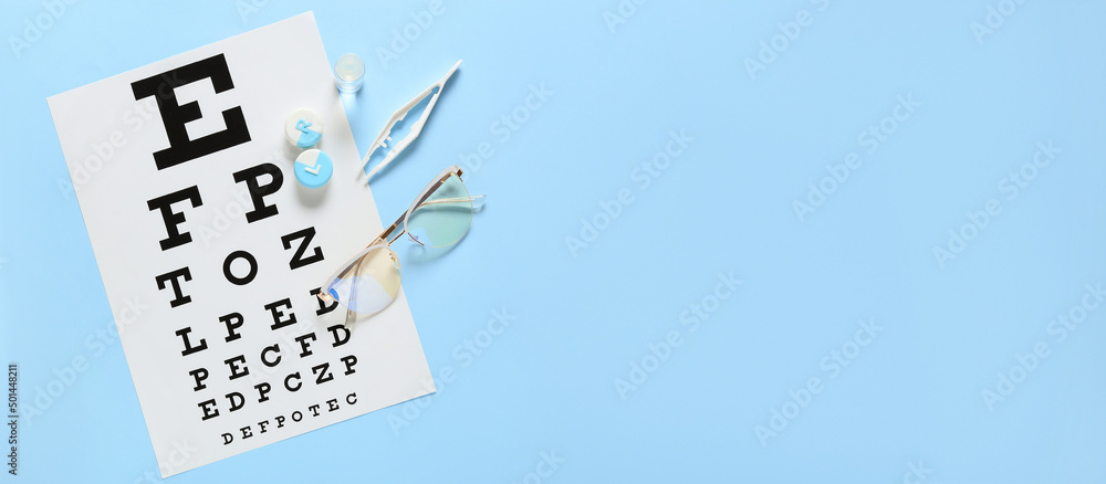 Wall mural Contact lenses, eye test chart and glasses on light blue background with space for text