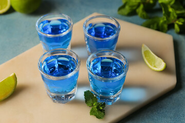 Shot cocktails and limes on color background, closeup